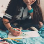Teenage girl pencil drawing at home